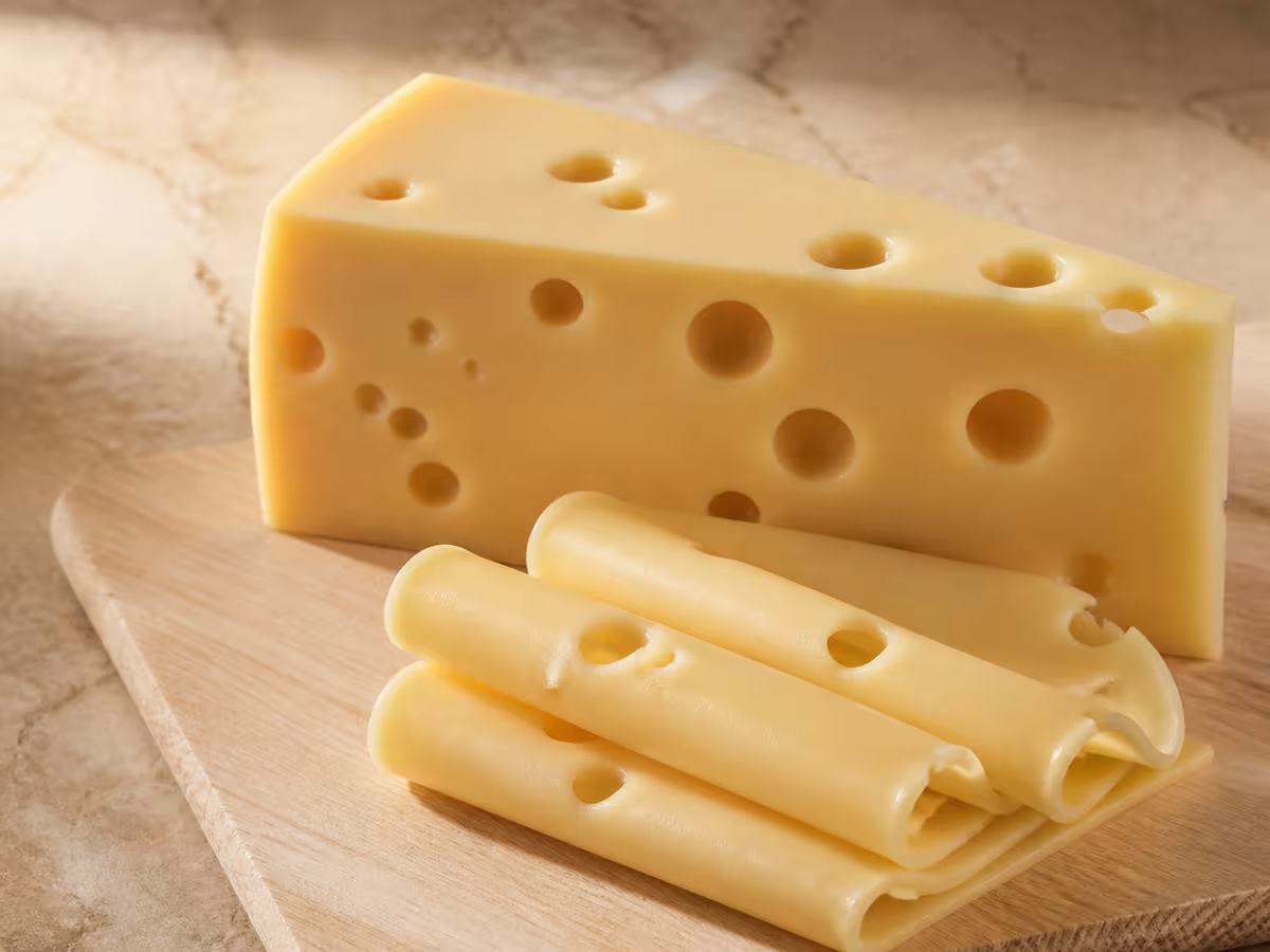 Cu&ntilde;a y lonchas de queso emmental de color amarillo p&aacute;lido