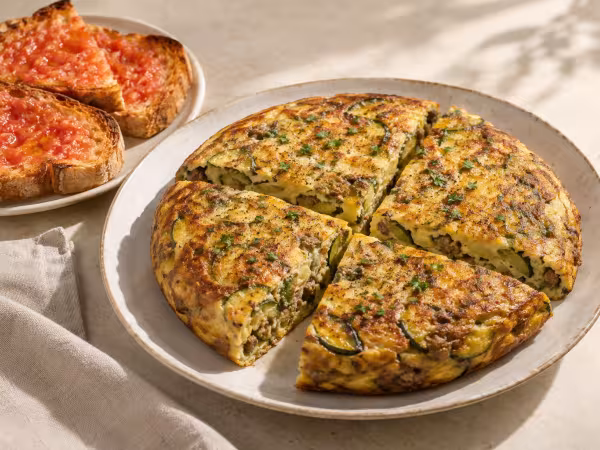 Tortilla de ternera y calabacín con tostadas de tomate servido