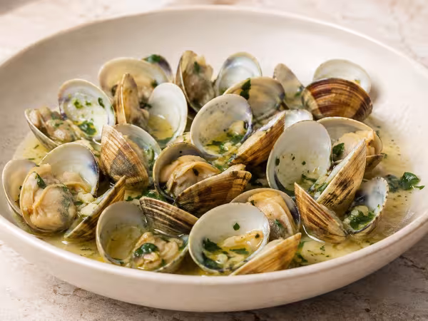 Clams in white wine sauce served on a light table