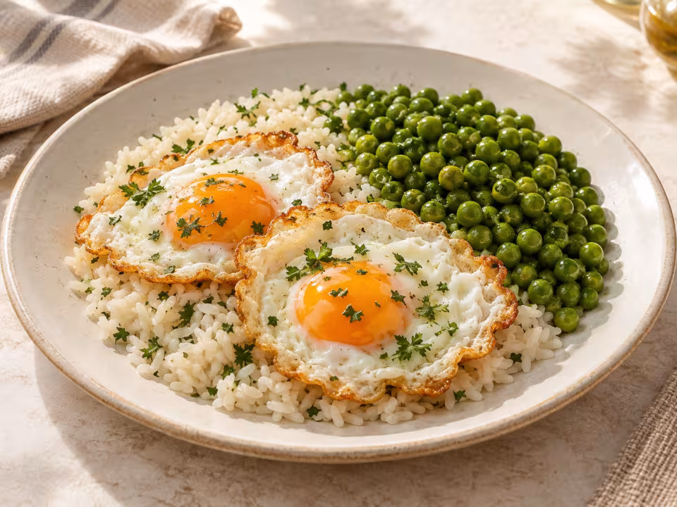 White rice with fried eggs and peas ready to serve