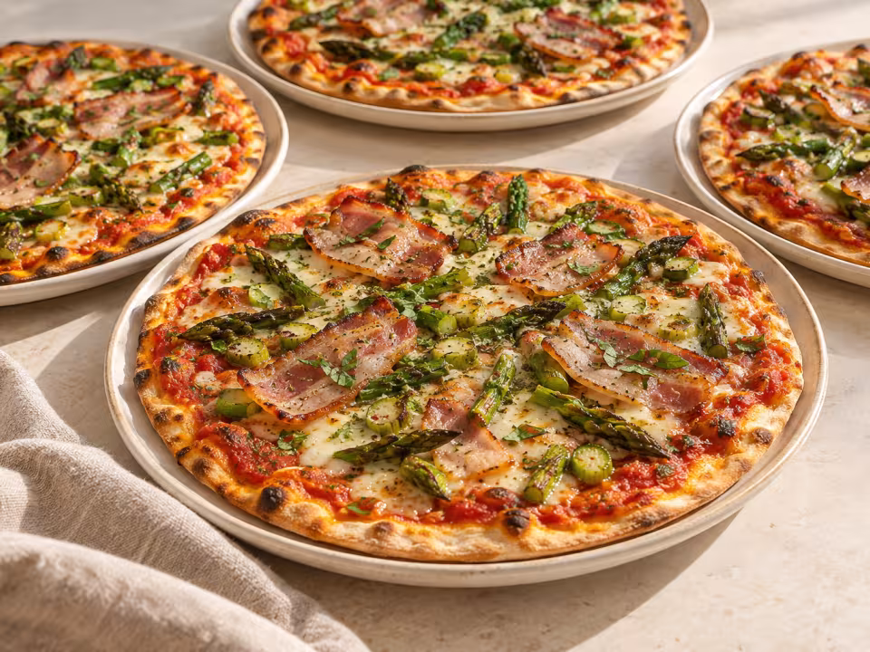 Thin asparagus and pork belly pizzas ready to serve