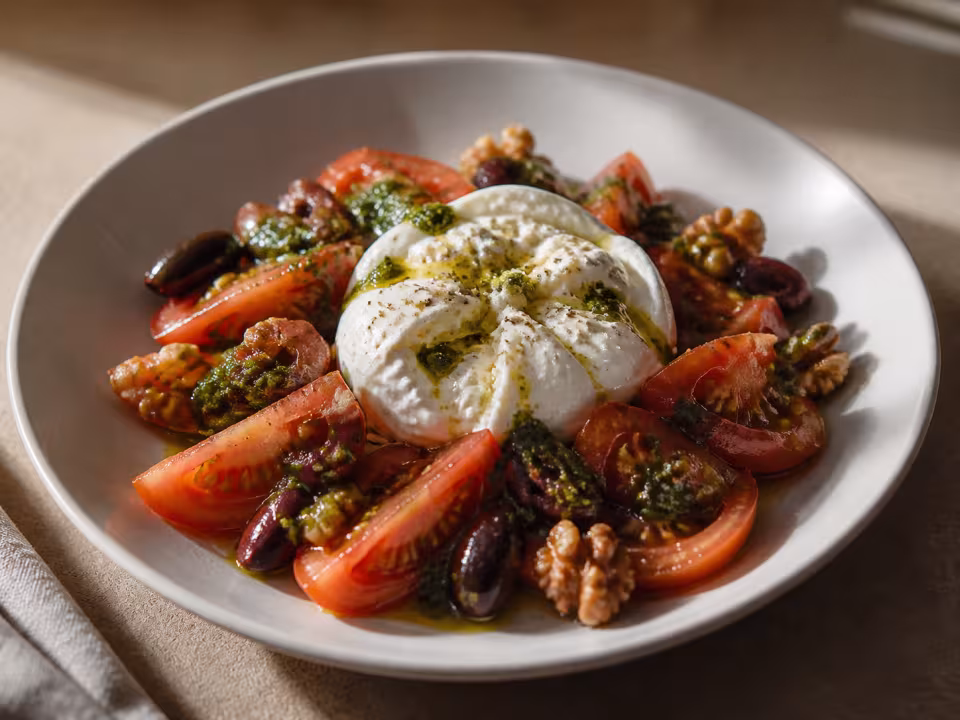 Tomates maduros con burratina, pesto, aceitunas negras y nueces