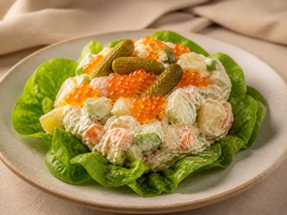 Ensaladilla de patata, pepino y zanahoria sobre lechuga con huevas de salm&oacute;n
