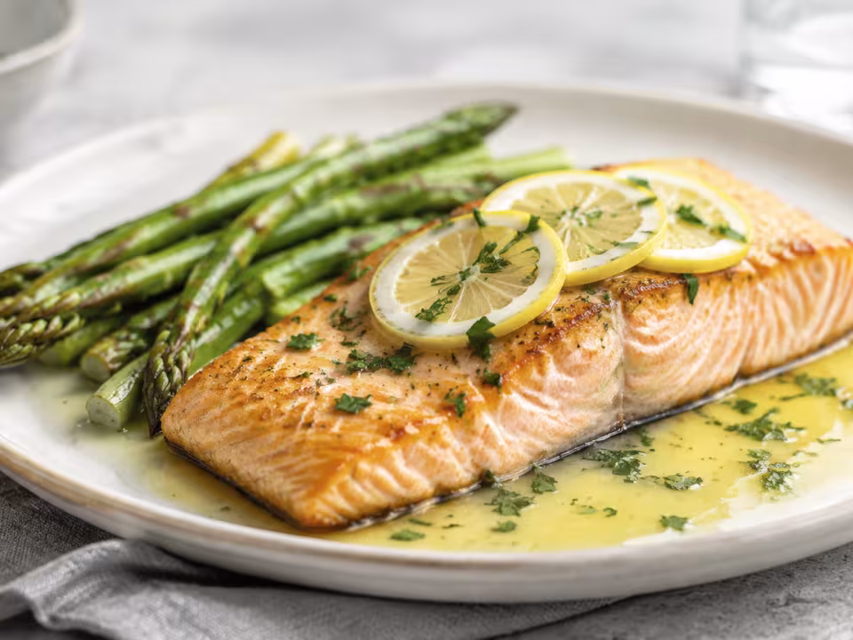 Salmon in lemon sauce with green asparagus plated and ready to eat