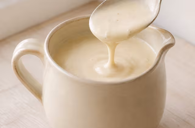 Salsa cocida de leche, harina y grasa, de textura lisa y cremosa.